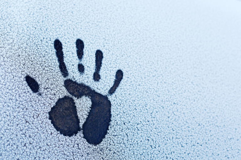 hand print on snow covered windshield