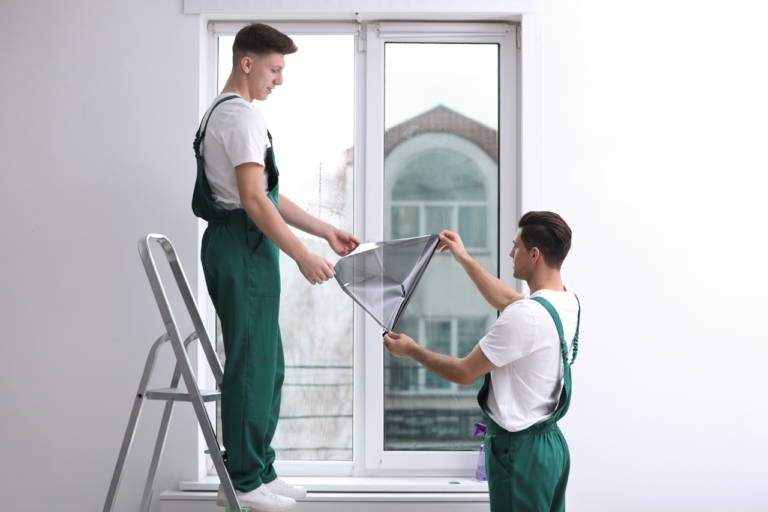 technicians apply window tint in home