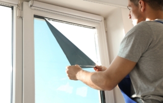 technician installs window tint on home door