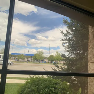 looking out a window with a parking lot in the distance