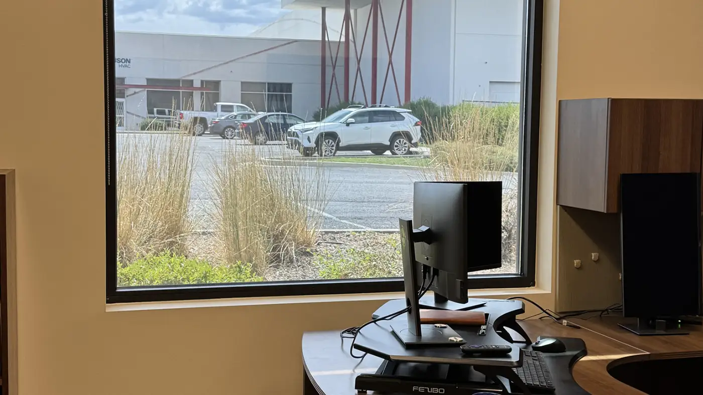 Office desk and computer next to a square window